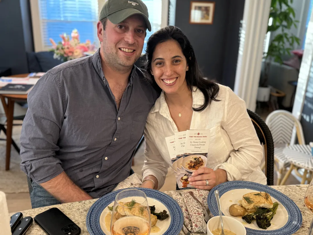 A couple smiling over the dinner they cooked together