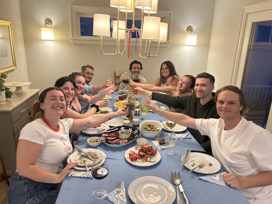 Guests smiling around a dinner table at a private chef evening